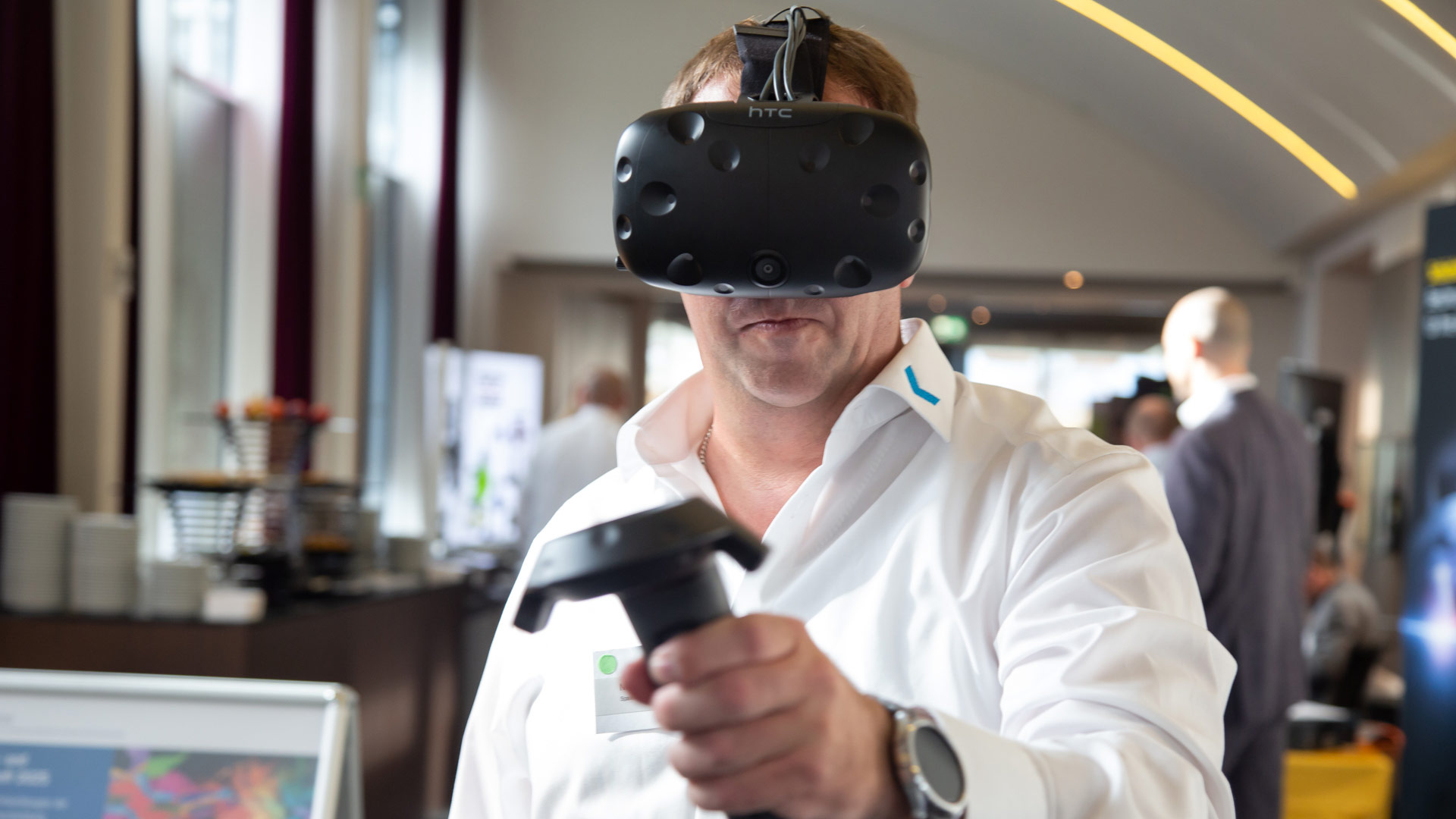 Konferenzteilnehmer mit einer Virtual Reality-Brille an einem Ausstellungsstand