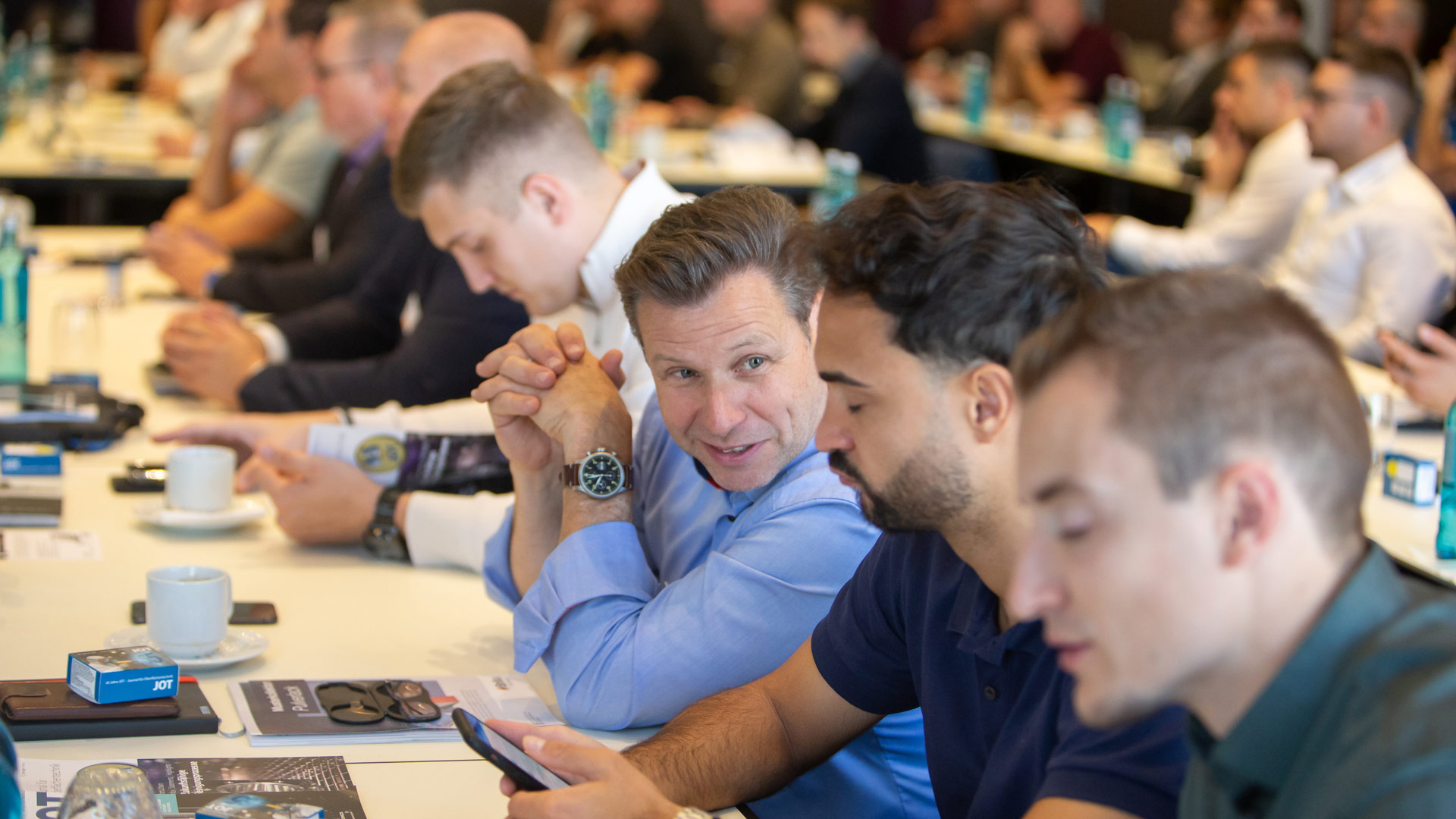 Viele Konferenzteilnehmer im Plenum sitzend