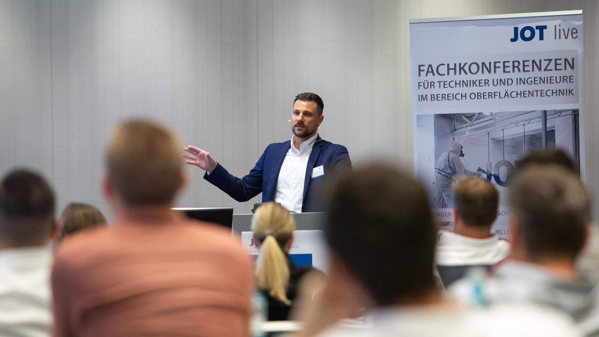 Referent auf der Bühne, im Vordergrund das Plenum