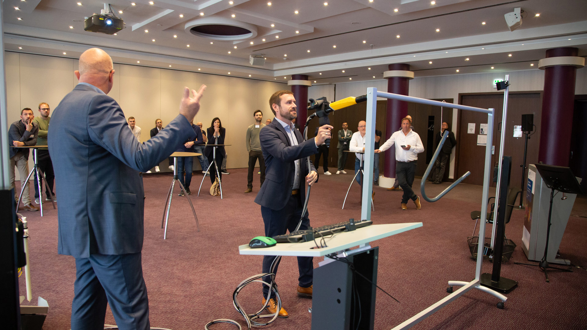 Konferenzteilnehmer während einer Live-Erprobung im Workspace. Im Hintergrund weitere Teilnehmer